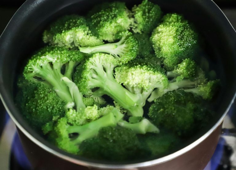Bright green broccoli florets boiling in a pot for a fresh, healthy meal.